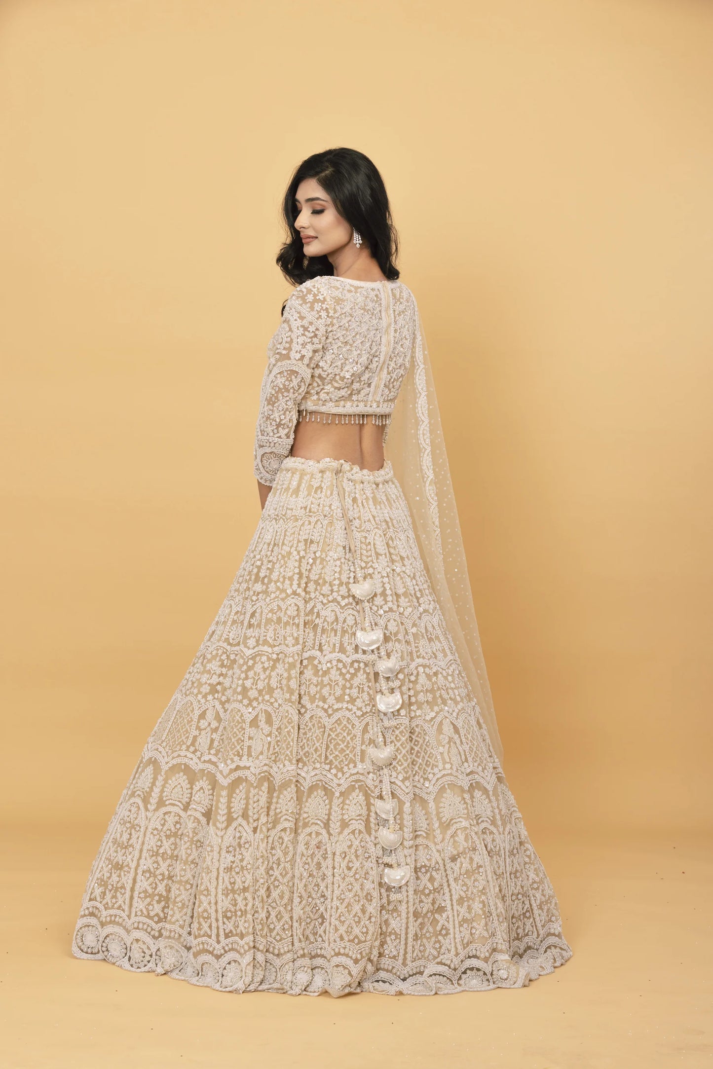 Beige net lehenga with pearl embellishments